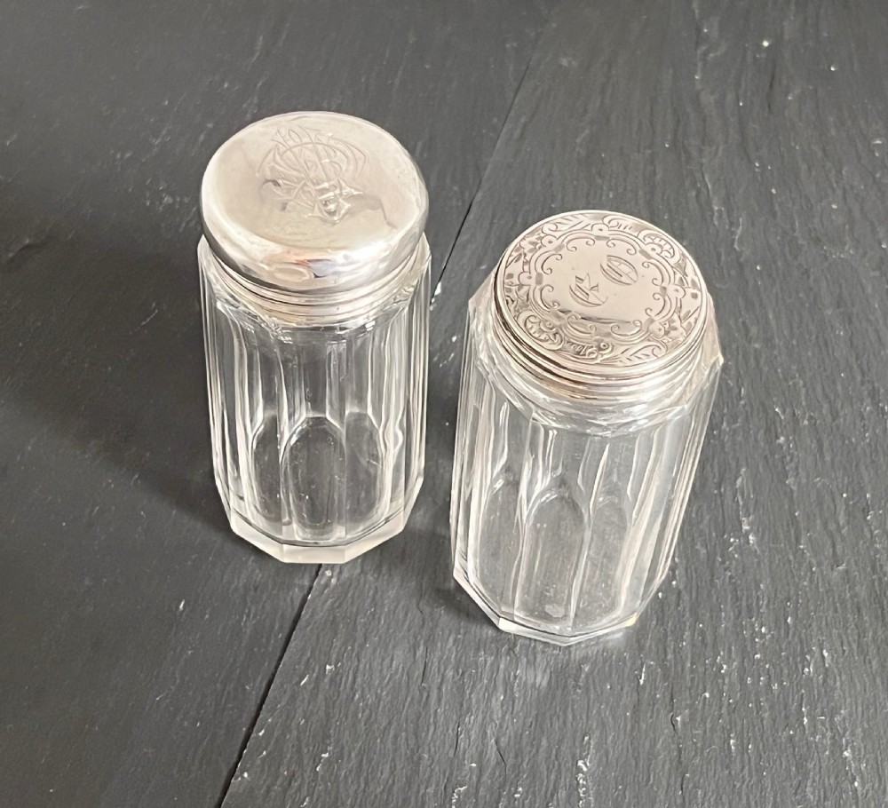 Pair of faceted clear cut glass vanity jars fitted with silver tops featuring engraved and chased detailing. View XIII