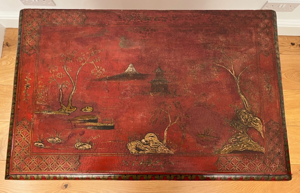 A red lacquered side table decorated with hand-painted gilt chinoiserie landscapes, featuring two drawers with brass handles and long cabriole legs. View V