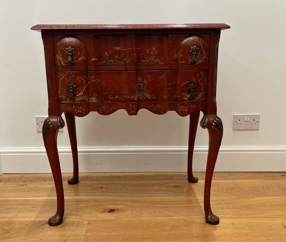 A red lacquered side table decorated with hand-painted gilt chinoiserie landscapes, featuring two drawers with brass handles and long cabriole legs. View VI