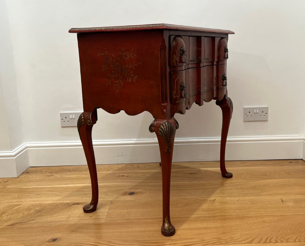 A red lacquered side table decorated with hand-painted gilt chinoiserie landscapes, featuring two drawers with brass handles and long cabriole legs. View VII
