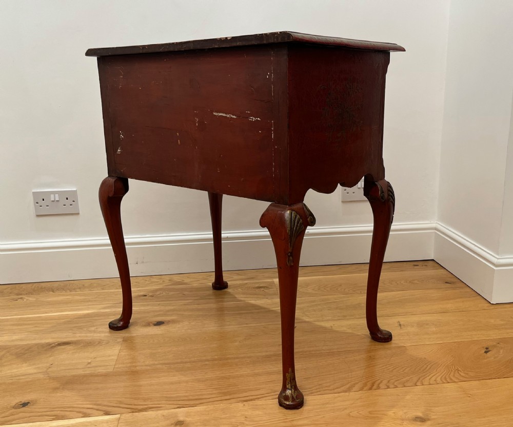 A red lacquered side table decorated with hand-painted gilt chinoiserie landscapes, featuring two drawers with brass handles and long cabriole legs. View IX
