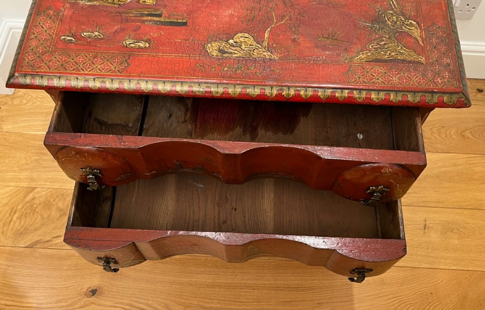 A red lacquered side table decorated with hand-painted gilt chinoiserie landscapes, featuring two drawers with brass handles and long cabriole legs. View XI
