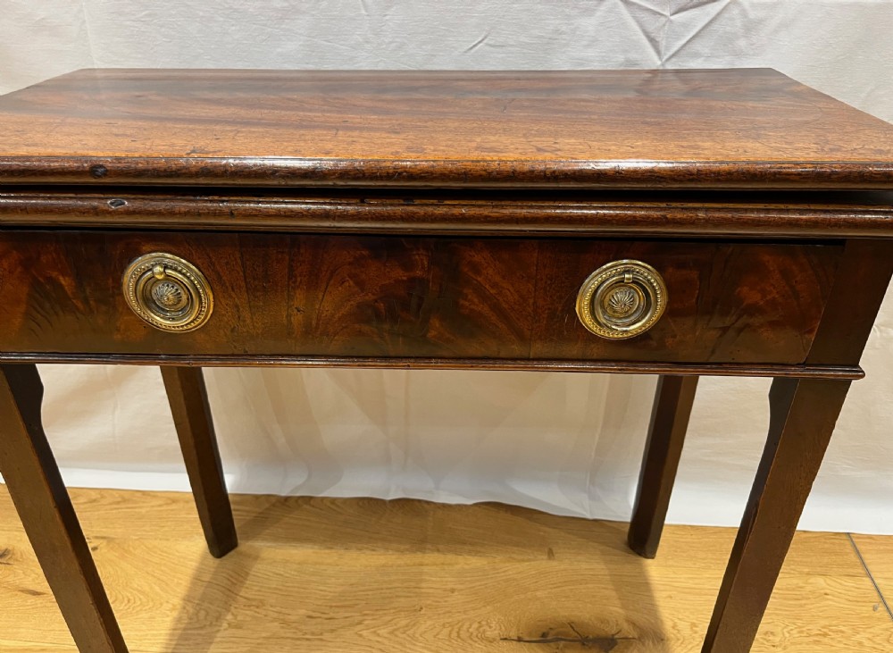 A Regency mahogany fold-over side table featuring tapered square legs, a single drawer with twin circular brass handles, and a hinged timber top. View II