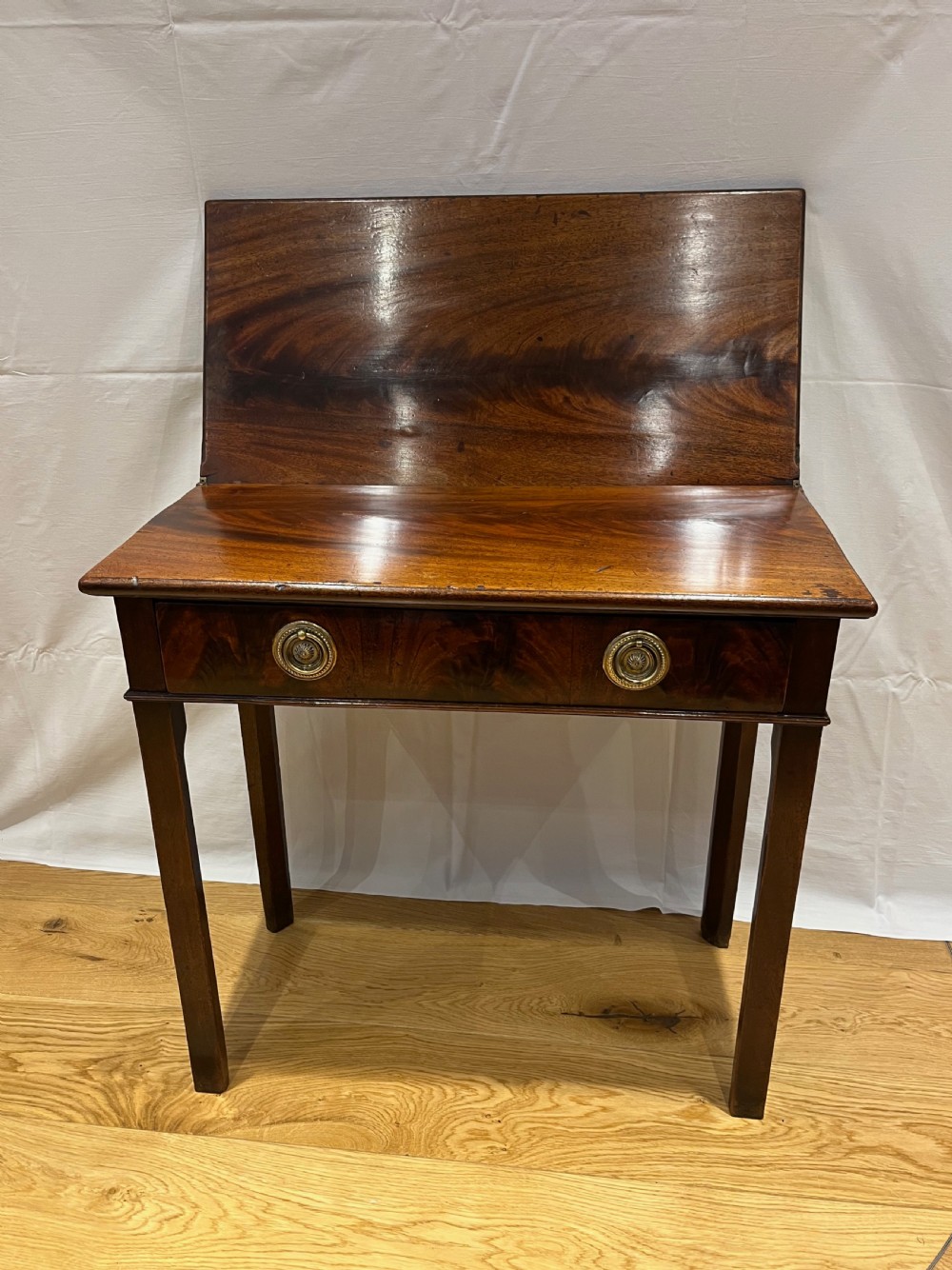 A Regency mahogany fold-over side table featuring tapered square legs, a single drawer with twin circular brass handles, and a hinged timber top. View IV