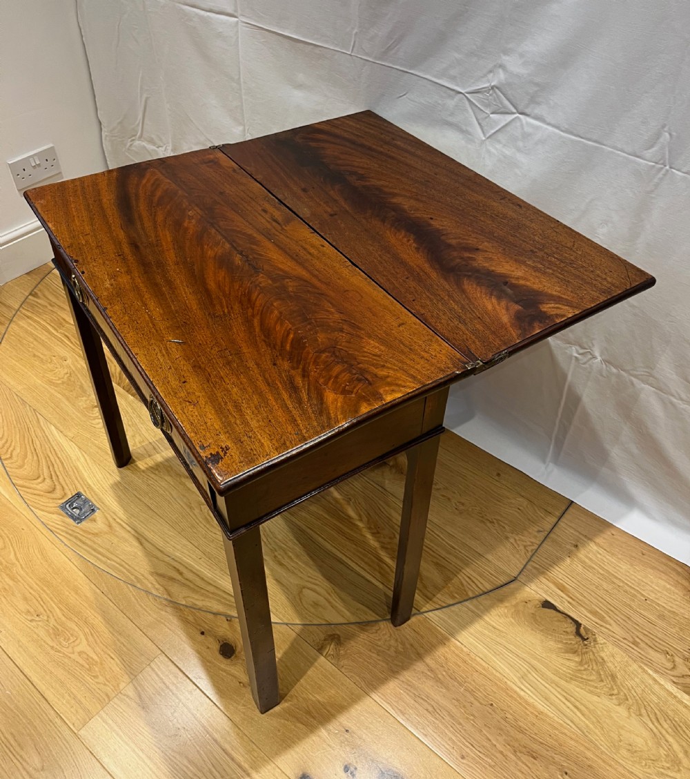 A Regency mahogany fold-over side table featuring tapered square legs, a single drawer with twin circular brass handles, and a hinged timber top. View V