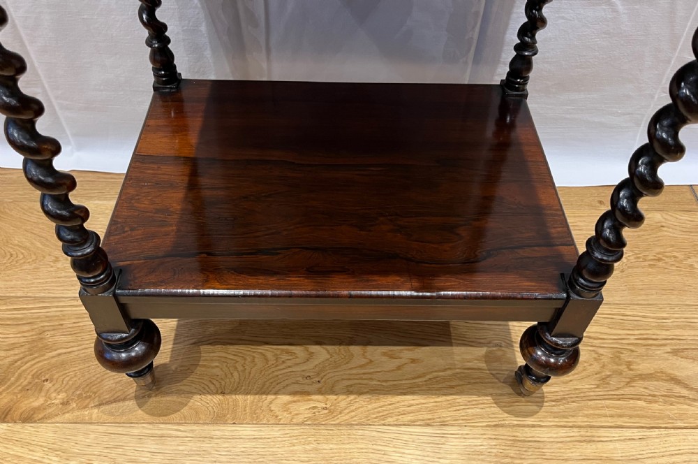 A mid-Victorian dark rosewood whatnot etagere featuring three open tiers, barley twist pillar supports, a central drawer, a gallery back, and turned feet. View III
