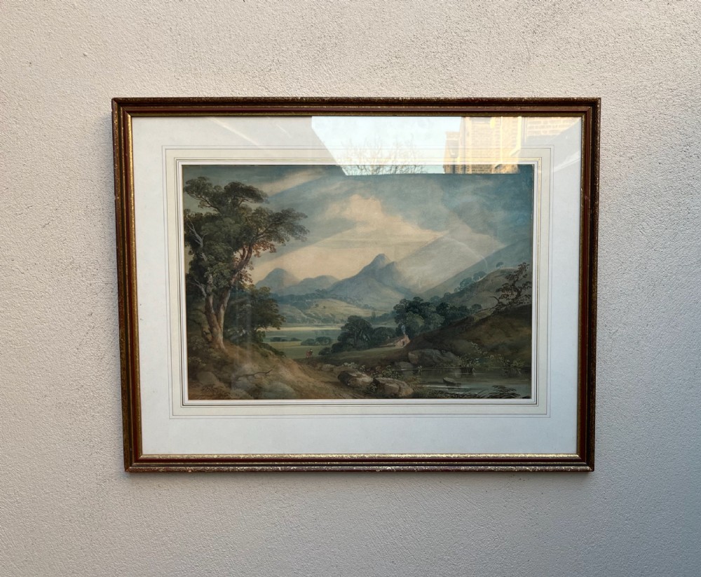 A framed 19th-century watercolour painting featuring a rustic cottage nestled among lush trees with livestock in a rolling landscape, presented in a gilt frame. View VII
