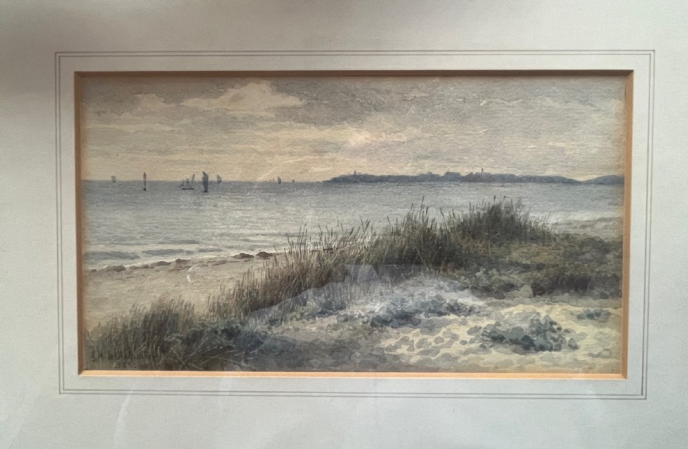 An antique framed watercolour painting depicting sand dunes in the foreground and distant sailboats on a calm sea under an overcast sky.