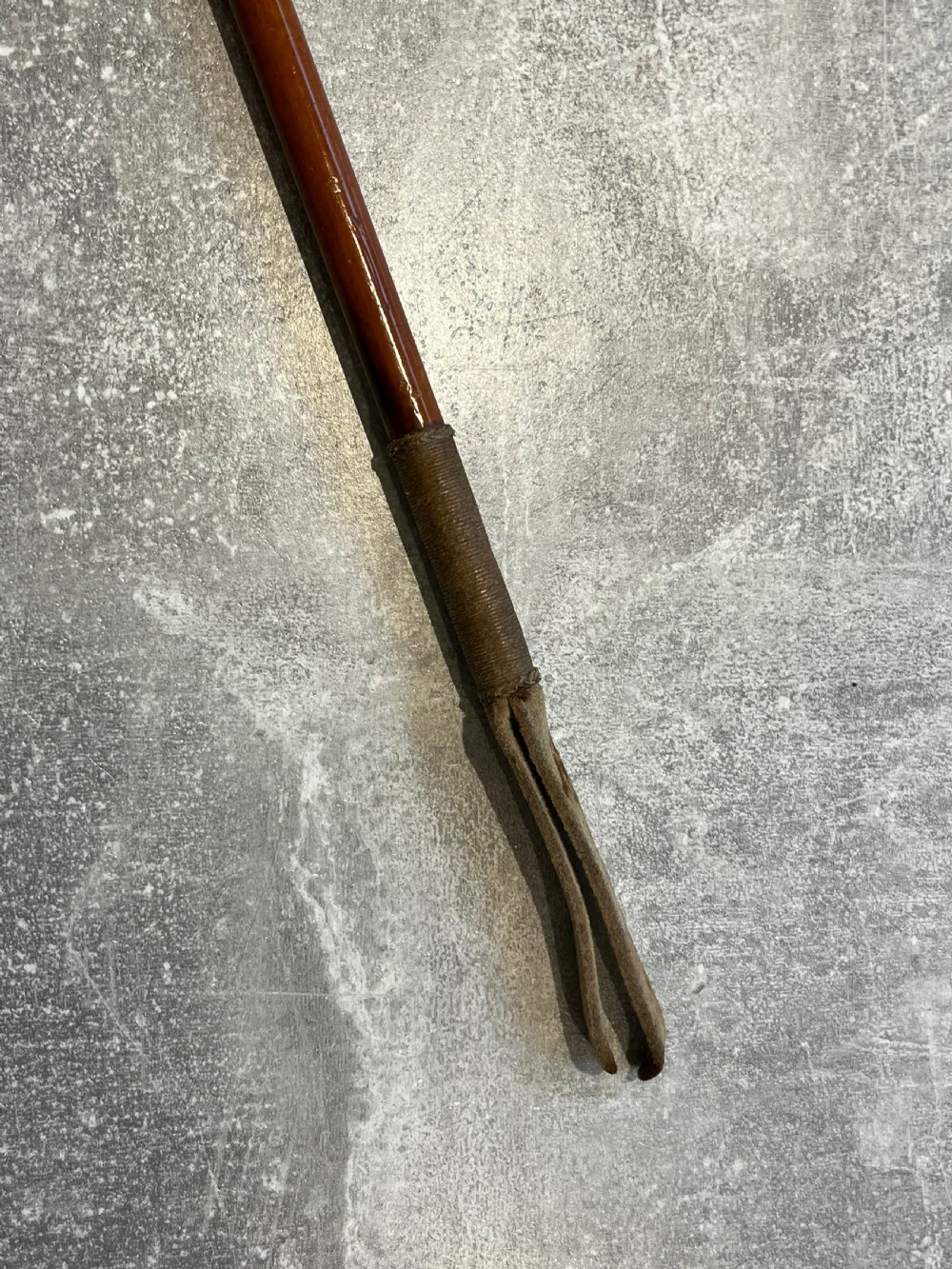 Close-up of a silver-mounted riding crop featuring a carved antler handle, a chased sterling silver collar, and a polished wooden shaft. View VIII