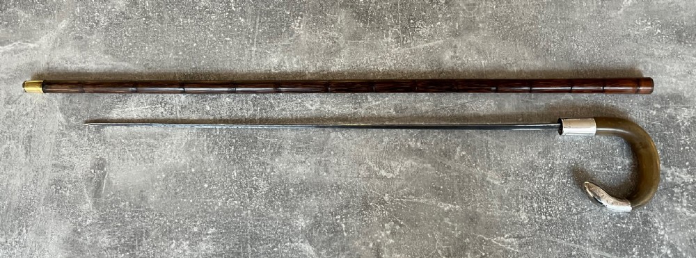 An Edwardian silver-mounted sword stick with a curved crook handle, silver collar bearing London hallmarks, and a partially unsheathed steel blade. View XI