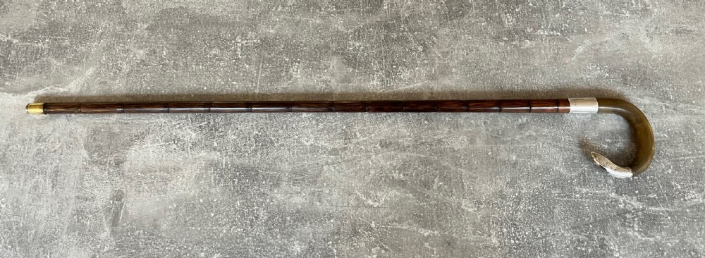 An Edwardian silver-mounted sword stick with a curved crook handle, silver collar bearing London hallmarks, and a partially unsheathed steel blade. View XII