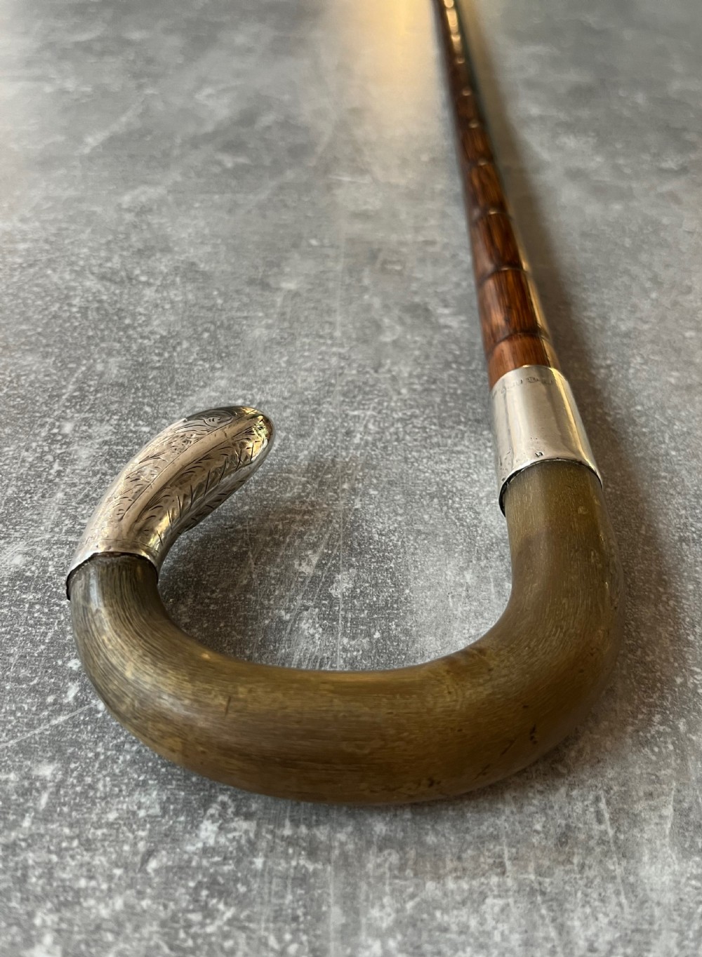 An Edwardian silver-mounted sword stick with a curved crook handle, silver collar bearing London hallmarks, and a partially unsheathed steel blade. View XIII