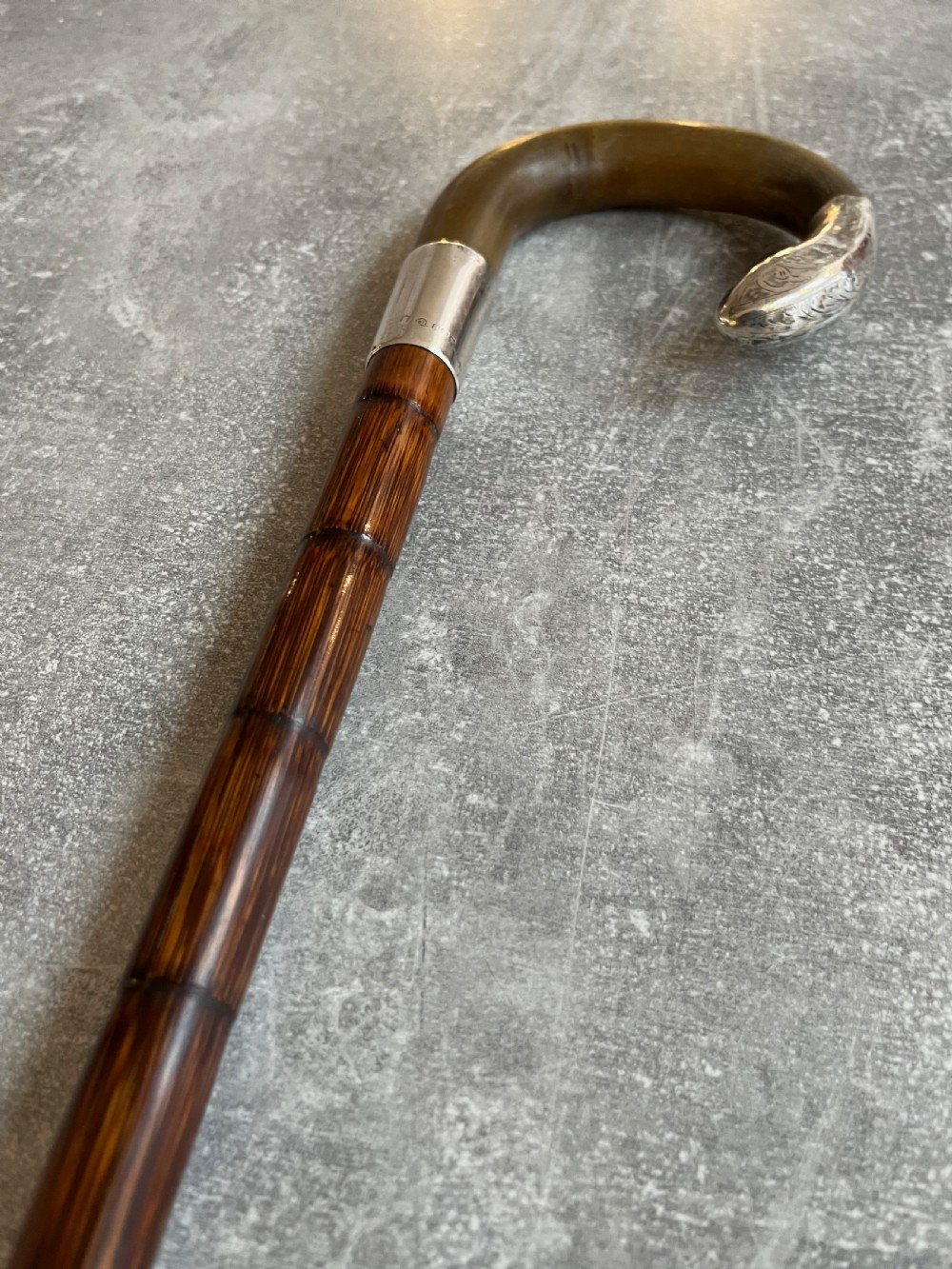 An Edwardian silver-mounted sword stick with a curved crook handle, silver collar bearing London hallmarks, and a partially unsheathed steel blade. View XIV