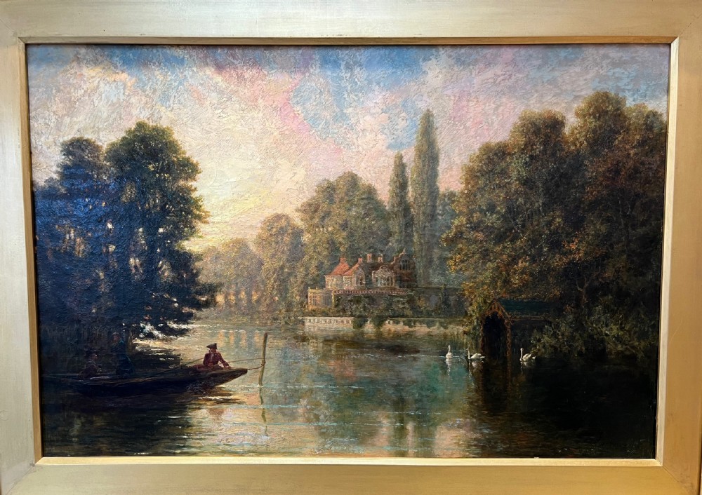 An antique framed oil painting depicting a tranquil river Thames scene with a figure in a boat, swans near a boathouse, and a riverbank estate beneath a glowing sky. View II