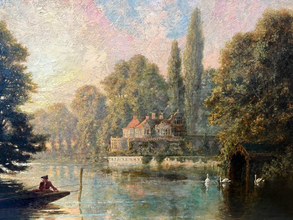 An antique framed oil painting depicting a tranquil river Thames scene with a figure in a boat, swans near a boathouse, and a riverbank estate beneath a glowing sky. View XII