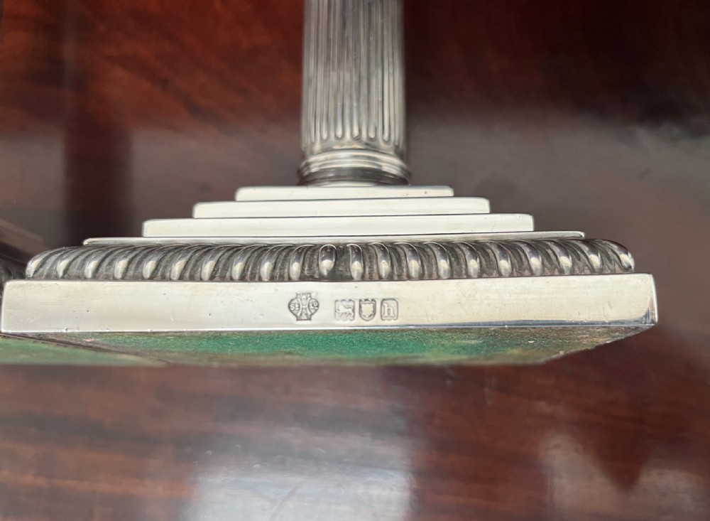 A pair of Edwardian sterling silver Corinthian column candlesticks on stepped square bases with gadrooned rims. View IV