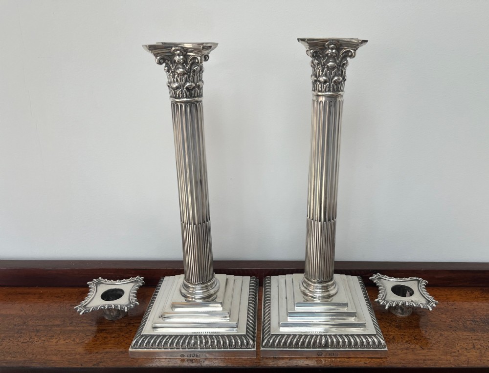 A pair of Edwardian sterling silver Corinthian column candlesticks on stepped square bases with gadrooned rims. View VI