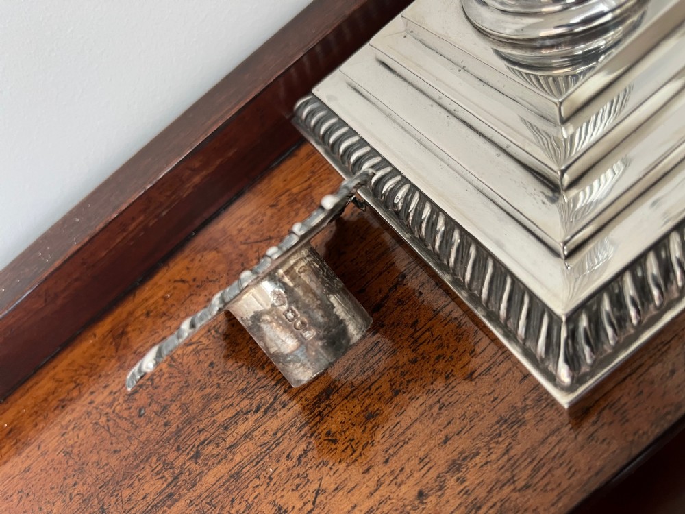 A pair of Edwardian sterling silver Corinthian column candlesticks on stepped square bases with gadrooned rims. View VII