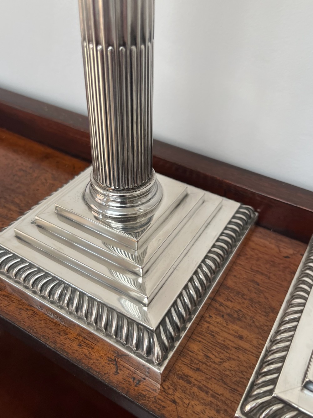 A pair of Edwardian sterling silver Corinthian column candlesticks on stepped square bases with gadrooned rims. View XIII