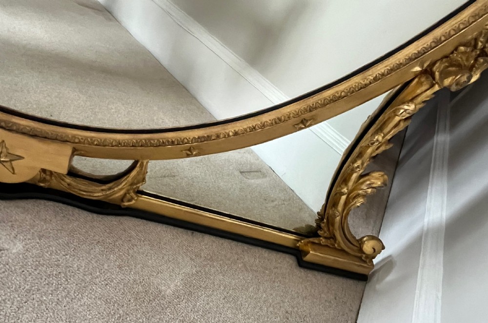 Large Victorian oval overmantel mirror featuring a gilded frame with star motifs, scrollwork base brackets, and an acanthus crest. View IV