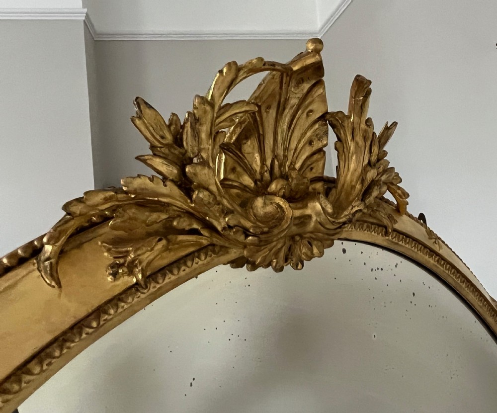Large Victorian oval overmantel mirror featuring a gilded frame with star motifs, scrollwork base brackets, and an acanthus crest. View VI