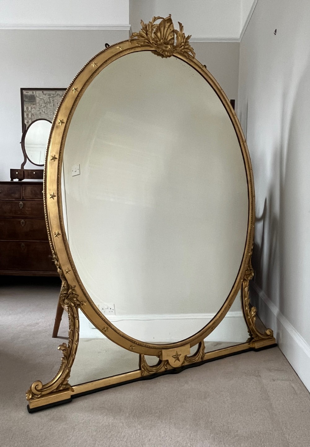 Large Victorian oval overmantel mirror featuring a gilded frame with star motifs, scrollwork base brackets, and an acanthus crest. View VII