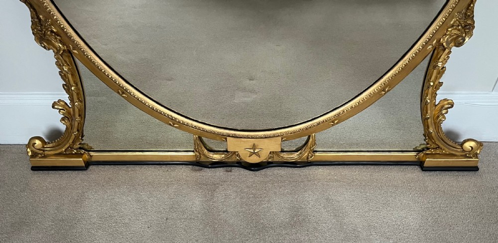 Large Victorian oval overmantel mirror featuring a gilded frame with star motifs, scrollwork base brackets, and an acanthus crest. View XII