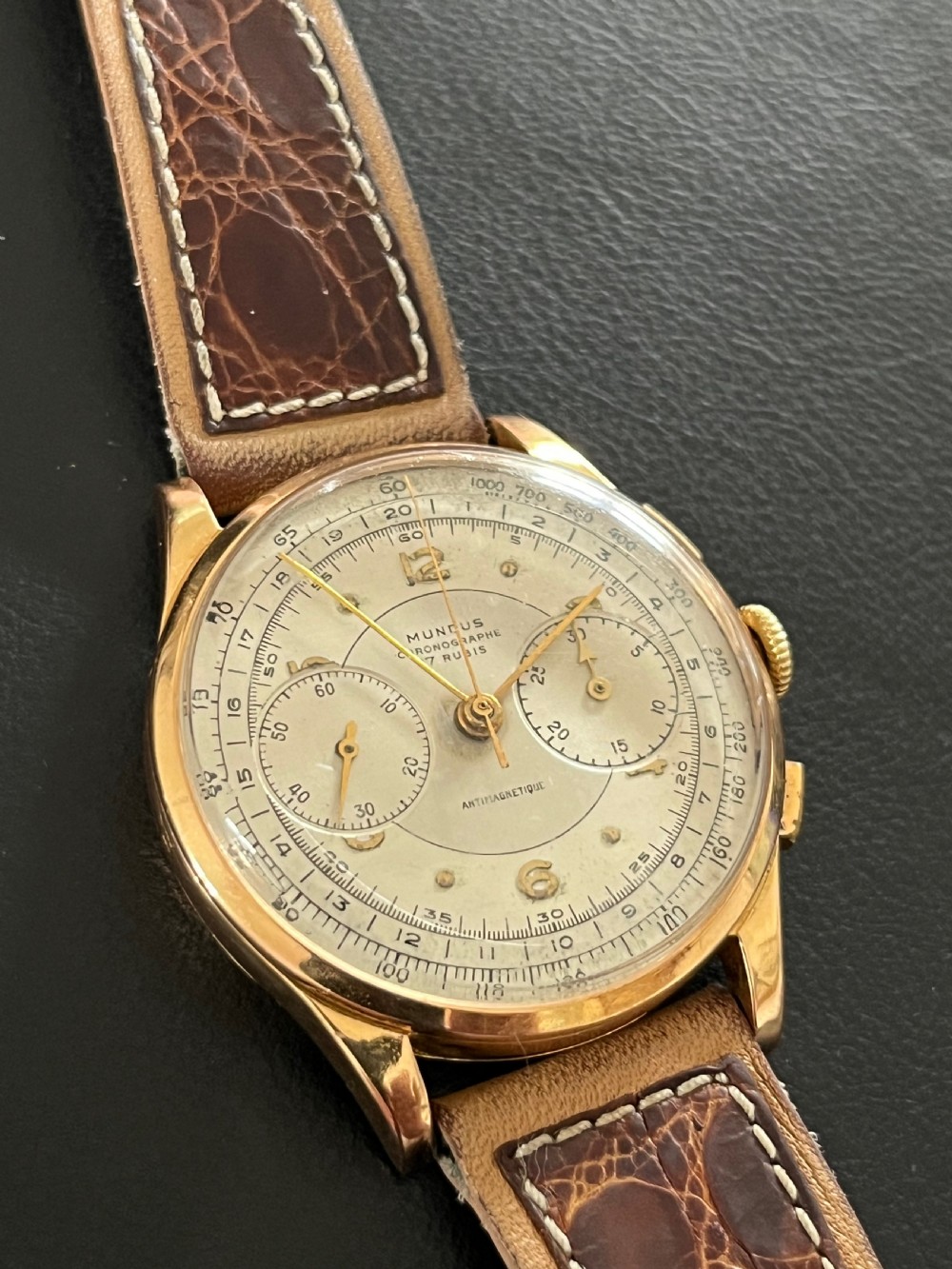 A vintage 18ct gold circular chronograph wristwatch featuring a silvered dial, dual sub-dials, gold hands, and a brown leather strap. View IX