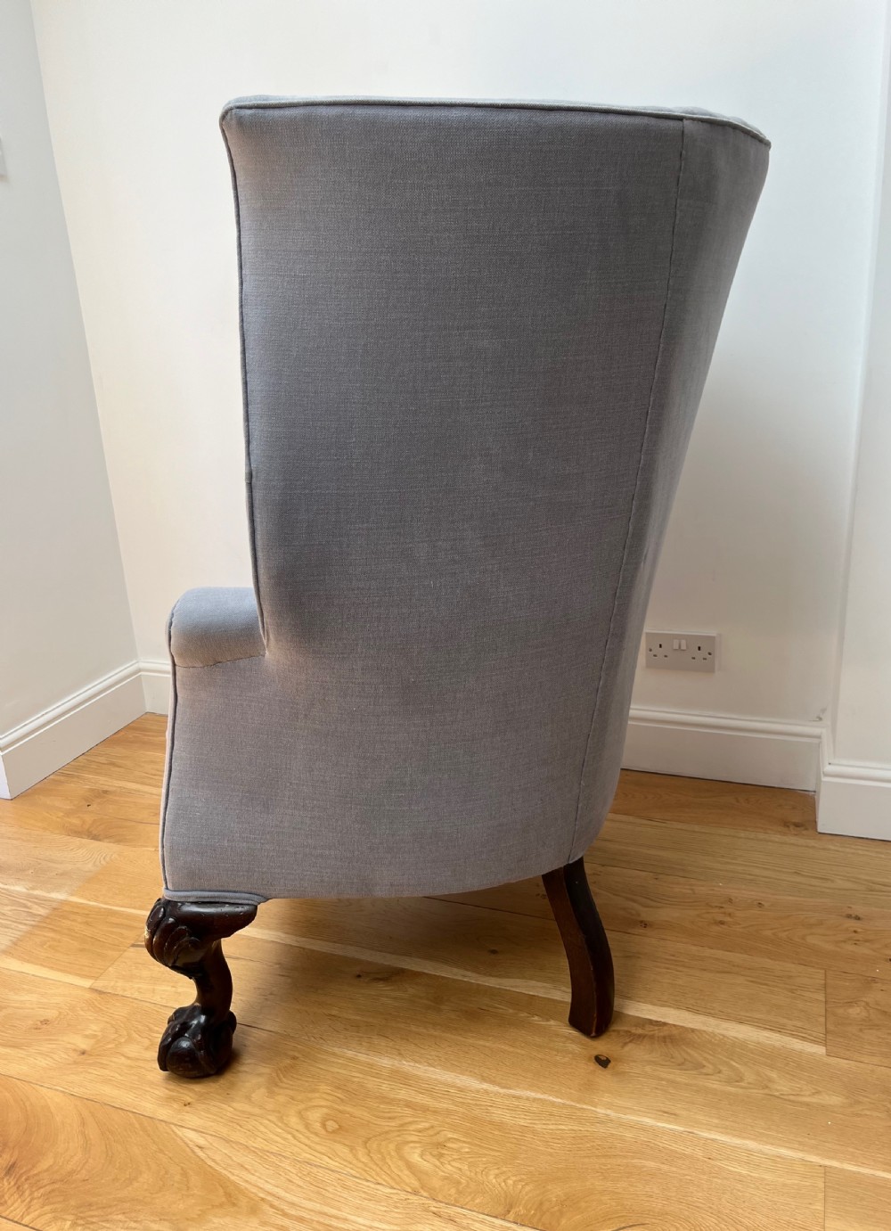 A high-backed Victorian barrel back armchair upholstered in light grey fabric, featuring channel-tufted back detailing and dark carved cabriole legs with ball and claw feet. View VII