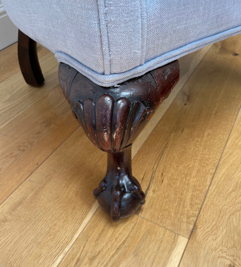 A high-backed Victorian barrel back armchair upholstered in light grey fabric, featuring channel-tufted back detailing and dark carved cabriole legs with ball and claw feet. View IX