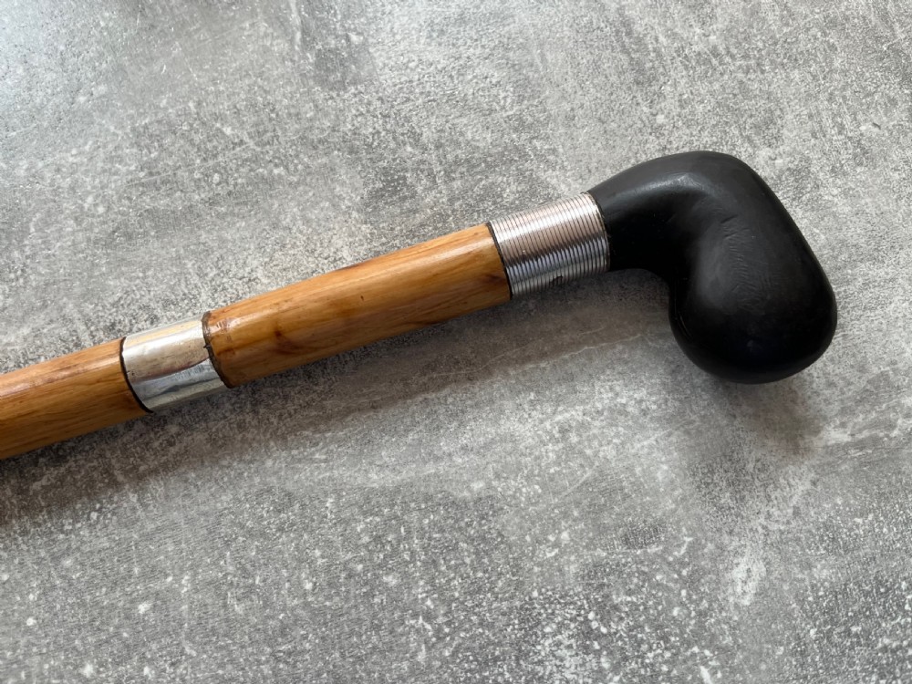 An antique bamboo walking stick shown disassembled to reveal a long steel blade and a dark curved pistol-grip handle with metal ferrules. View III