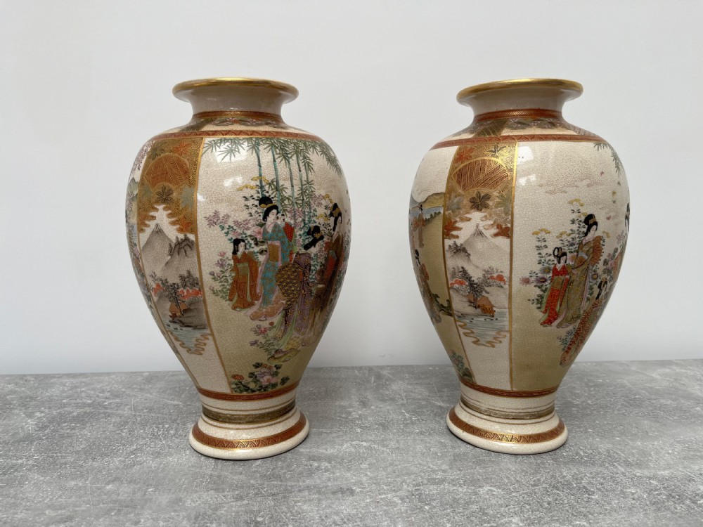A pair of baluster-shaped Japanese Satsuma earthenware vases decorated with painted figures in landscapes under a crackled cream glaze with gilded borders. View III