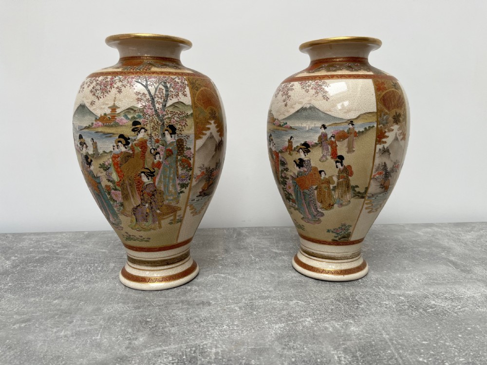 A pair of baluster-shaped Japanese Satsuma earthenware vases decorated with painted figures in landscapes under a crackled cream glaze with gilded borders. View IV