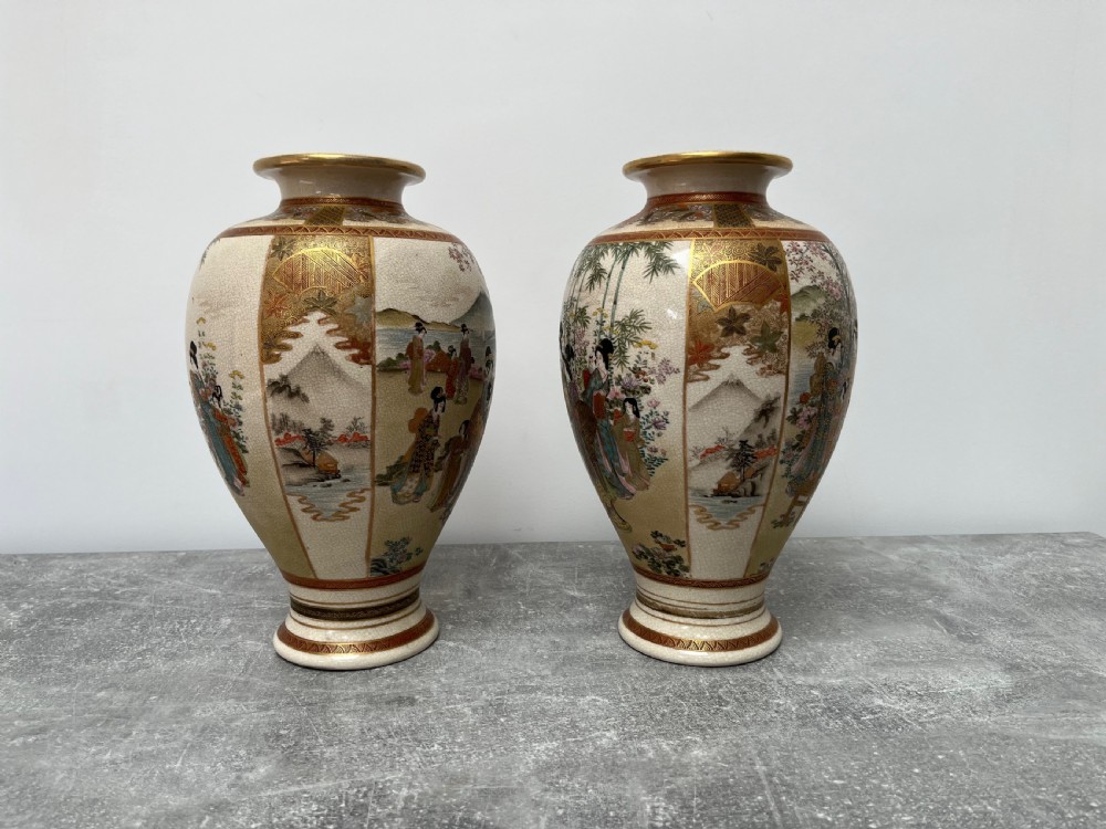 A pair of baluster-shaped Japanese Satsuma earthenware vases decorated with painted figures in landscapes under a crackled cream glaze with gilded borders. View VI