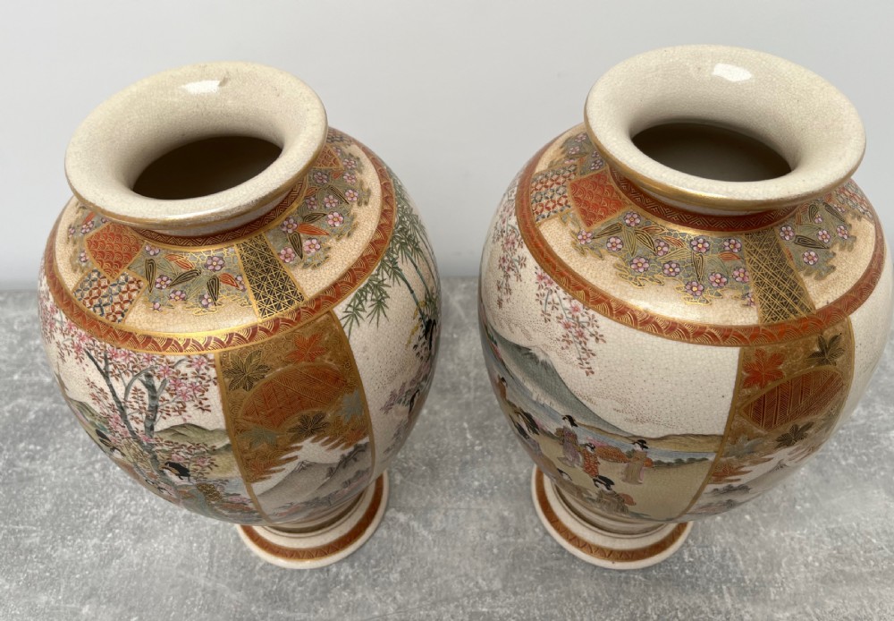 A pair of baluster-shaped Japanese Satsuma earthenware vases decorated with painted figures in landscapes under a crackled cream glaze with gilded borders. View VIII