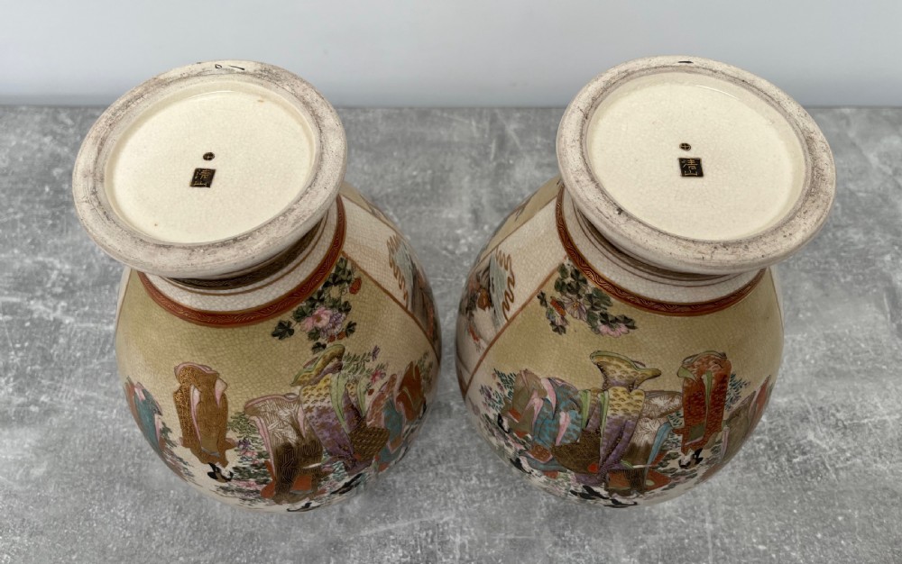 A pair of baluster-shaped Japanese Satsuma earthenware vases decorated with painted figures in landscapes under a crackled cream glaze with gilded borders. View IX