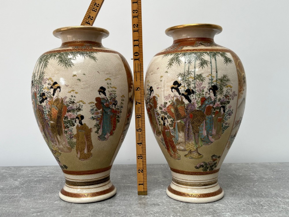 A pair of baluster-shaped Japanese Satsuma earthenware vases decorated with painted figures in landscapes under a crackled cream glaze with gilded borders. View XII