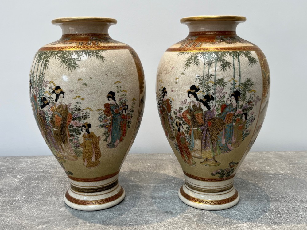 A pair of baluster-shaped Japanese Satsuma earthenware vases decorated with painted figures in landscapes under a crackled cream glaze with gilded borders. View XIII
