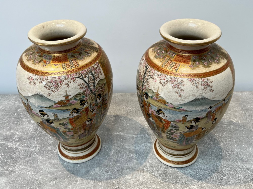 A pair of baluster-shaped Japanese Satsuma earthenware vases decorated with painted figures in landscapes under a crackled cream glaze with gilded borders. View XIV