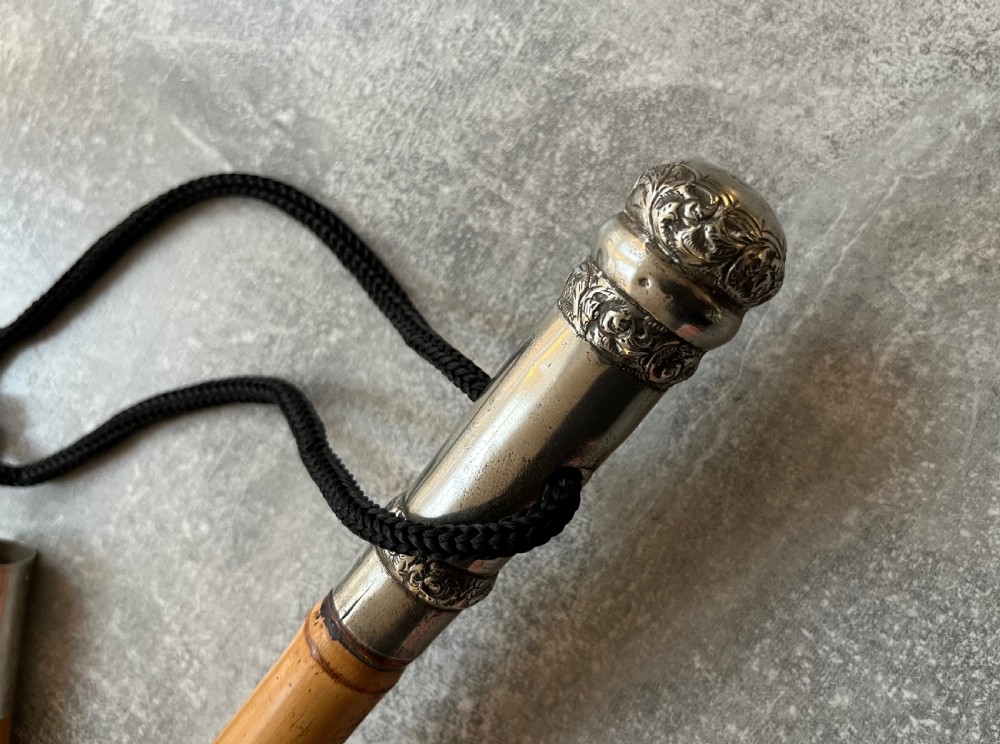 An early twentieth-century bamboo sword stick featuring an embossed silver pommel, a narrow steel blade, and a woven black wrist cord. View IV