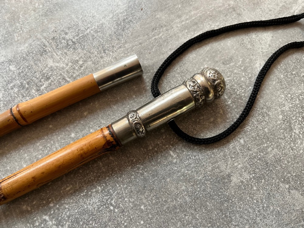 An early twentieth-century bamboo sword stick featuring an embossed silver pommel, a narrow steel blade, and a woven black wrist cord. View IX