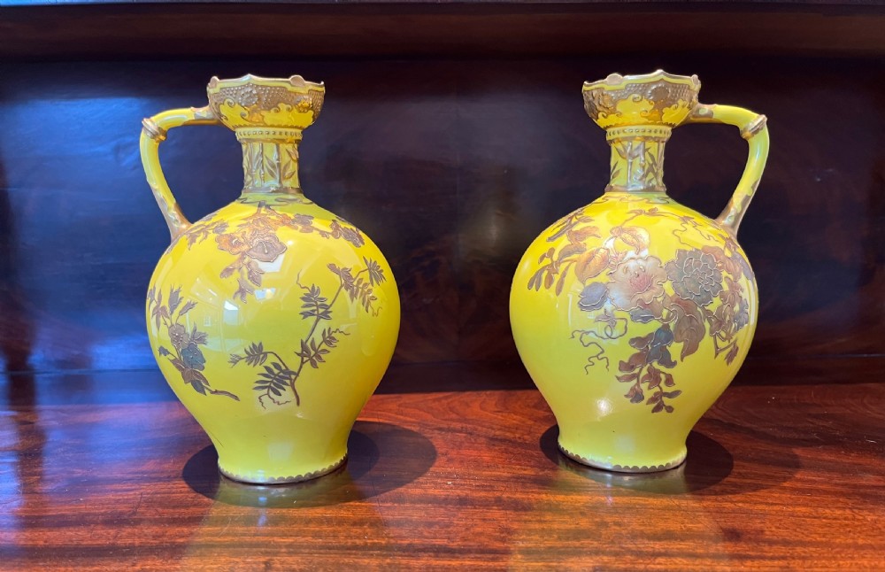 A pair of yellow porcelain ewers with gilded floral decoration, narrow necks, and single handles. View II