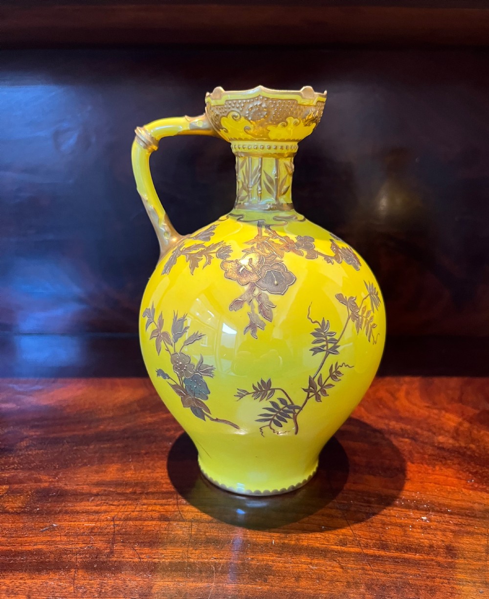 A pair of yellow porcelain ewers with gilded floral decoration, narrow necks, and single handles. View VI