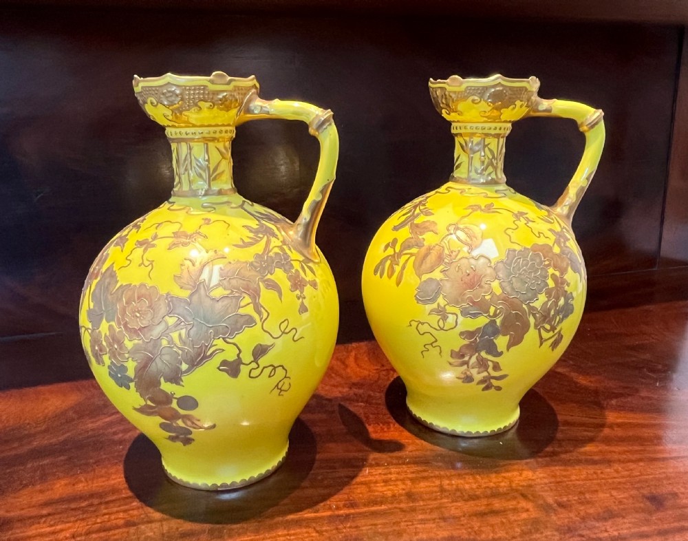 A pair of yellow porcelain ewers with gilded floral decoration, narrow necks, and single handles. View XIV