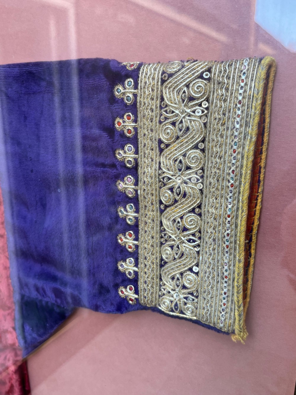 A late 19th-century Ottoman red velvet and purple silk jacket with heavy gold metallic embroidery, presented inside a thin gold wood frame. View IV