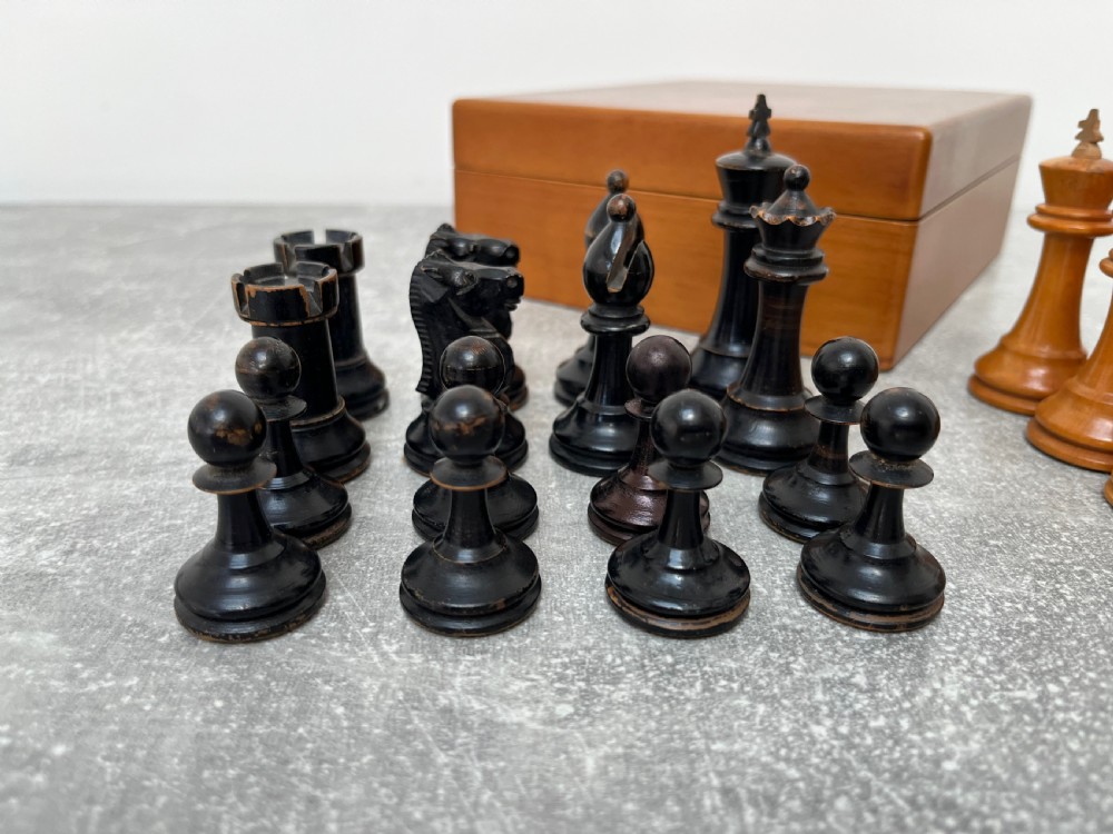 A wooden folding chess board featuring geometric inlaid borders and a full set of light and dark Staunton style chess pieces. View VI