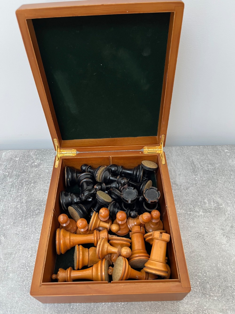 A wooden folding chess board featuring geometric inlaid borders and a full set of light and dark Staunton style chess pieces. View VII