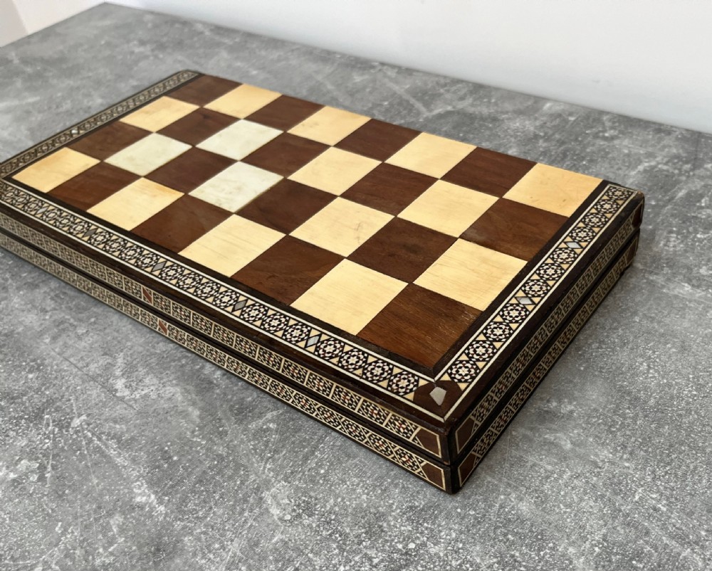 A wooden folding chess board featuring geometric inlaid borders and a full set of light and dark Staunton style chess pieces. View XI