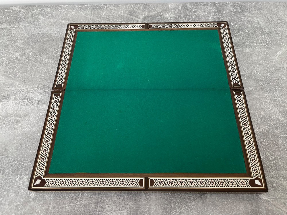 A wooden folding chess board featuring geometric inlaid borders and a full set of light and dark Staunton style chess pieces. View XII