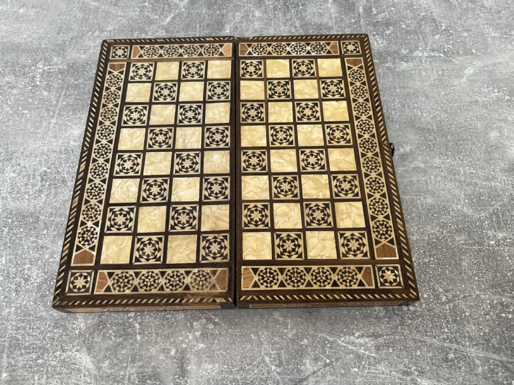A hinged wooden folding games board featuring intricate geometric micro-mosaic marquetry and mother-of-pearl star motifs.
